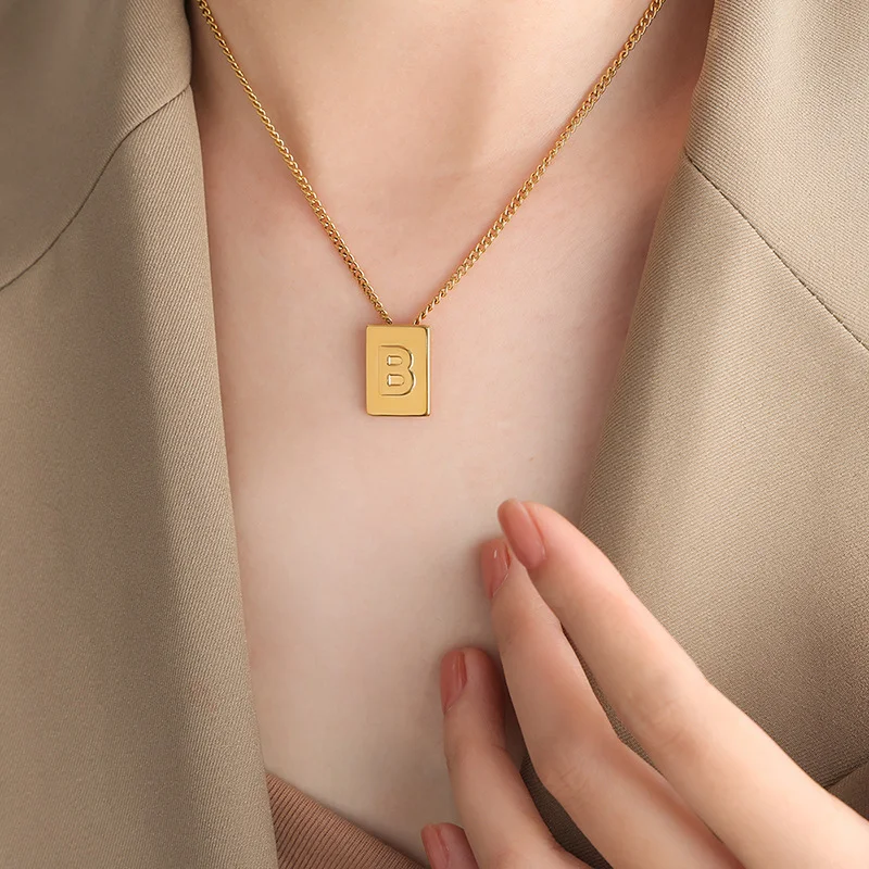 Ženska ogrlica sa priveskom od 26 slova, kvadratna, od titanijumskog čelika, pozlaćena. Elegantan i personalizovan dodatak.