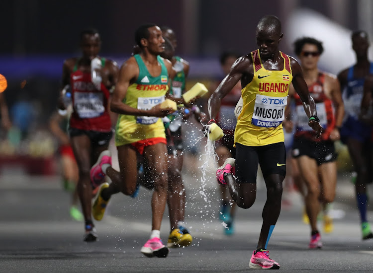 Uganda's Fred Musobo grabs a sponge to cool off during the World Championships in Doha, Qatar