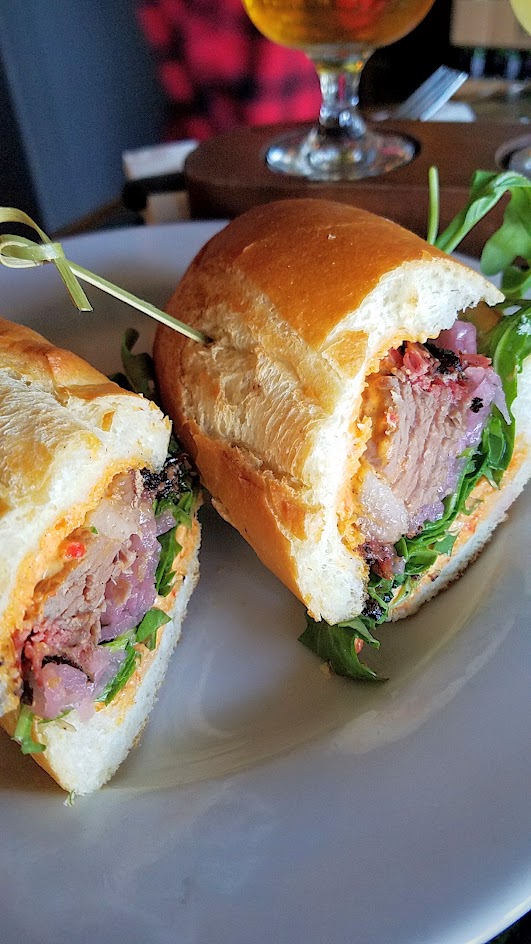 Example Food at Saraveza Smoked Brisket Sandwich with pimento cheese, red onion pickle, and arugula