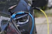 Two electric cars charge at a public charge station in Berlin, Germany. Germany is increasing its network of charging stations.