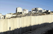 The Shuafat refugee camp behind a section of the controversial Israeli barrier in the West Bank. Israeli and Palestinian negotiators this week met at the negotiating table for the first time in three years