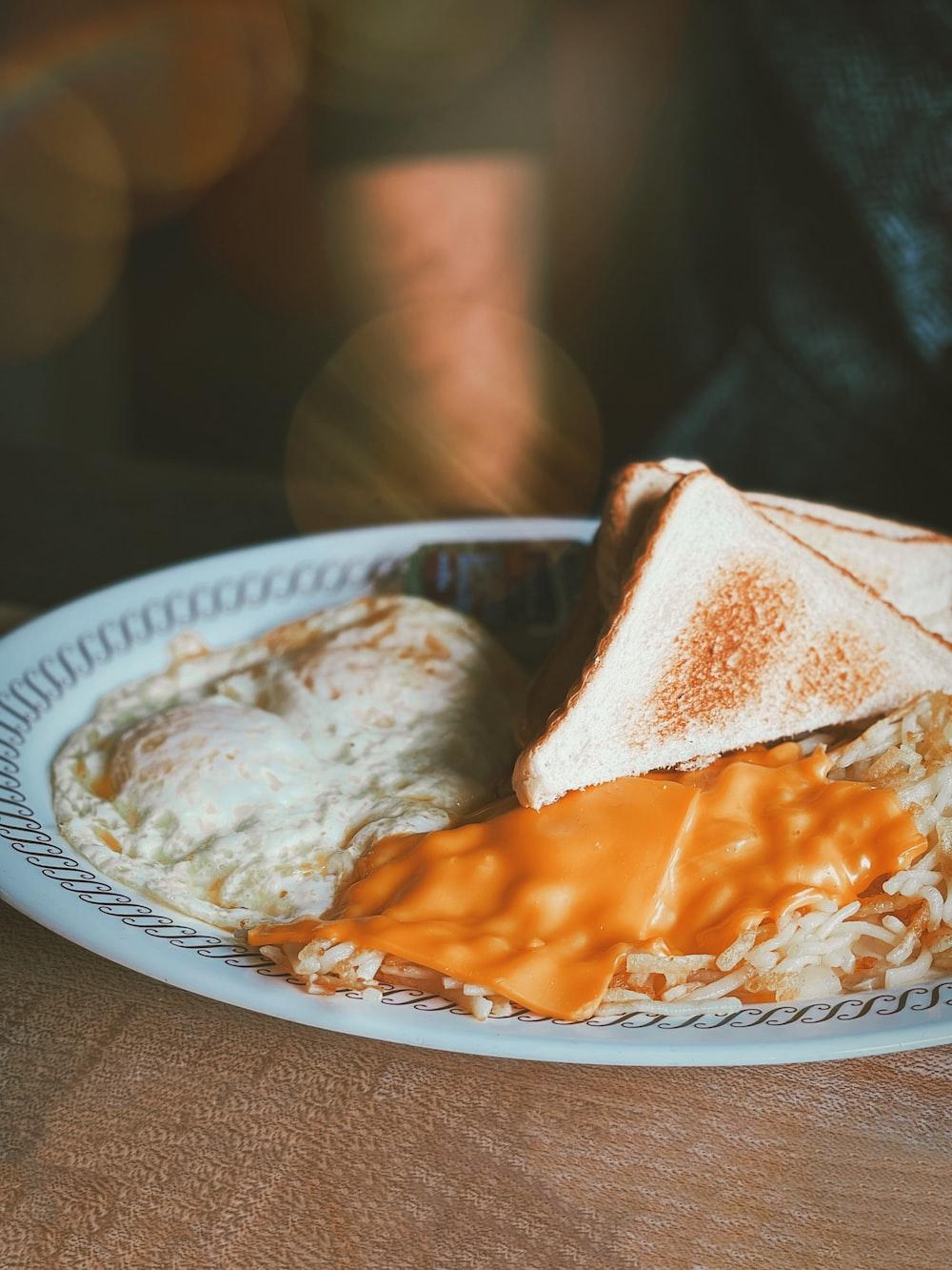 person holding white and blue round plate with brown and white food