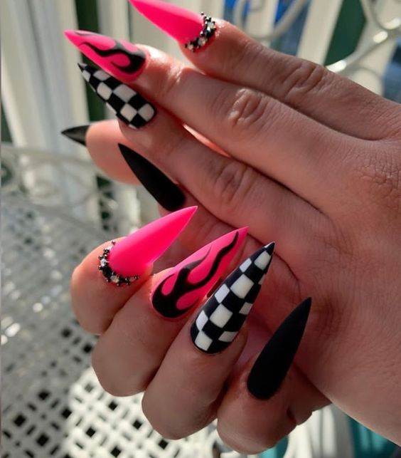 Imagem com unha stiletto com nail art rosa choque, preto e branco