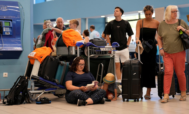 Tourists wait for departing planes at the airport after being evacuated following a wildfire on the island of Rhodes, Greece, July 23 2023. Picture: FEDJA GRULOVIC/REUTERS