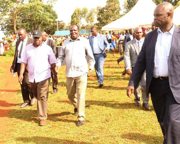 Interior CS Dr Fred Matiang'i with Kakamega governor Wycliffe Oparanya arrive for a public meeting at Matungu on Thursday.