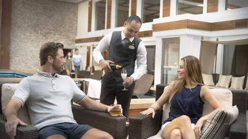 norwegian-bliss-haven-courtyard.jpg -  A server pours champagne for guests in the Haven Courtyard. 