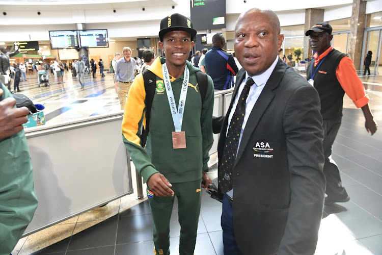 Thabang Mosiako is welcomed home by Athletics SA president James Moloi at OR Tambo airport on Tuesday morning.