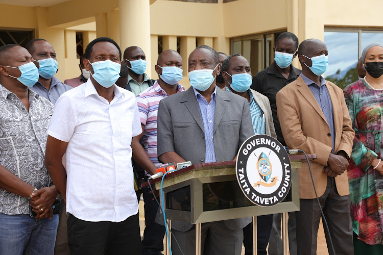 NLC chairman Gershom Otachi with Taita Taveta Governor Granton Samboja (left) addresses press outside the governor's office in Mwatate on July 12