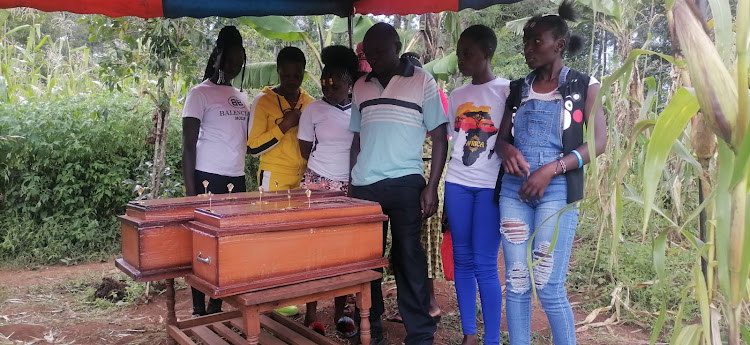 Mourners view bodies of slain Michelle and Glory during their burial Monday at Kiobegi in Bobasi, Kisii.