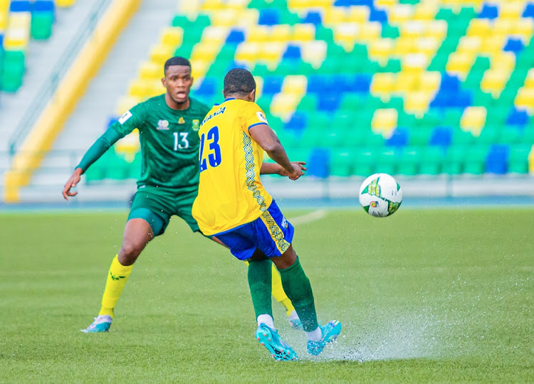 Water splashes off the synthetic surface as Olivier Niyonzima of Rwanda makes a pass under the attentions of Bafana Bafana's Sphephelo Sithole during the 2026 Fifa World Cup qualifier at Stade Huye in Butare, Rwanda on Tuesday.