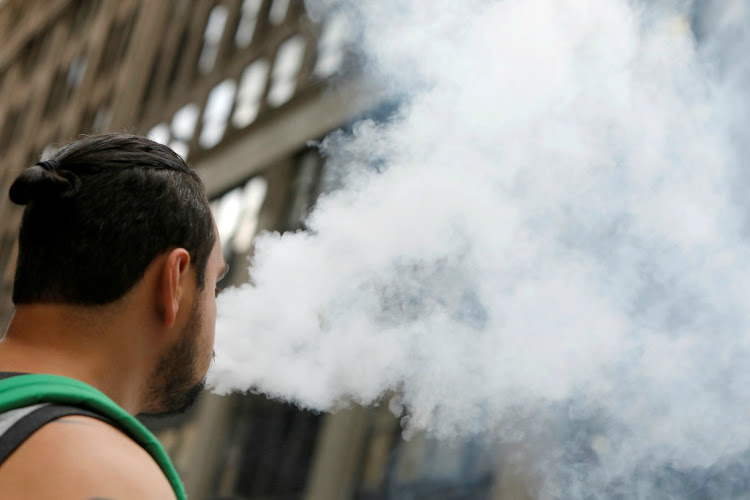 A man uses a vape as he walks on Broadway in New York City, US, on September 9, 2019. Picture: REUTERS/ANDREW KELLY