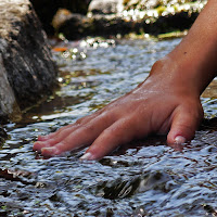 Sfiorare l'acqua con le dita di 