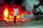 A Somali firefighter  at the site of a car bomb attack in Mogadishu on Monday . At least six people were killed and 10  injured. MOHAMED ABDIWAHAB /AFP PHOTO