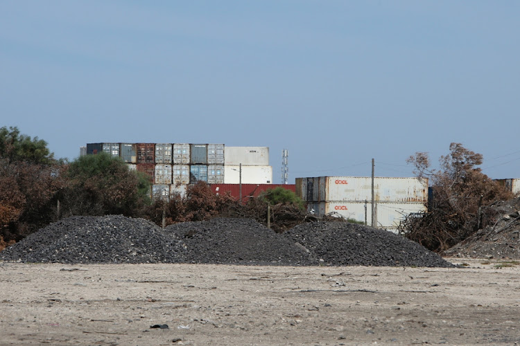 Business owners in the Markman industrial area are complaining about manganese pollution as well as the damage done to the roads by trucks. Pictured is a large amount of manganese that has been offloaded next to the railway line