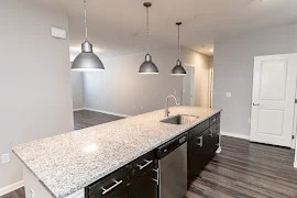 Large kitchen island with granite countertop and dark cabinets