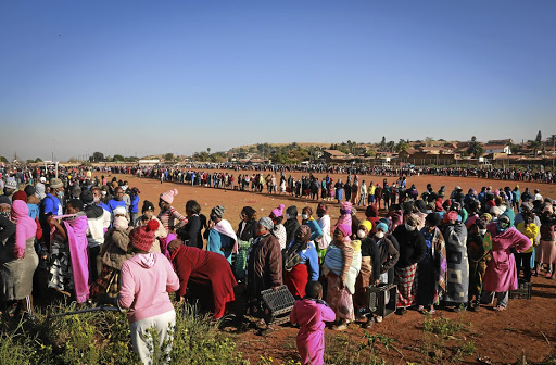 People queue to collect food parcels donated by community organisations and businesses at the Iterileng informal settlement near Laudium in Pretoria.