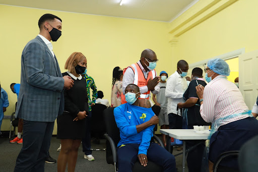 Mamelodi Sundowns chairperson Tlhopie Motsepe watches as midfielder George Maluleka receives his Covid-19 vaccine jab at Chloorkop on September 13 2021.