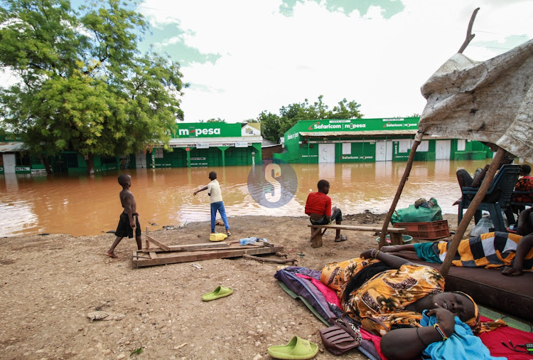 Families affected by floods in Mororo pack along the road after relocating when River Tana burst its banks following heavy rains on April 27, 2024.