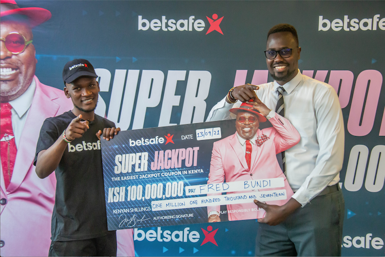 Fred Bundi (L) receives a Sh1.1 million cheque from Betsafe Kenya's Mavin Waganda