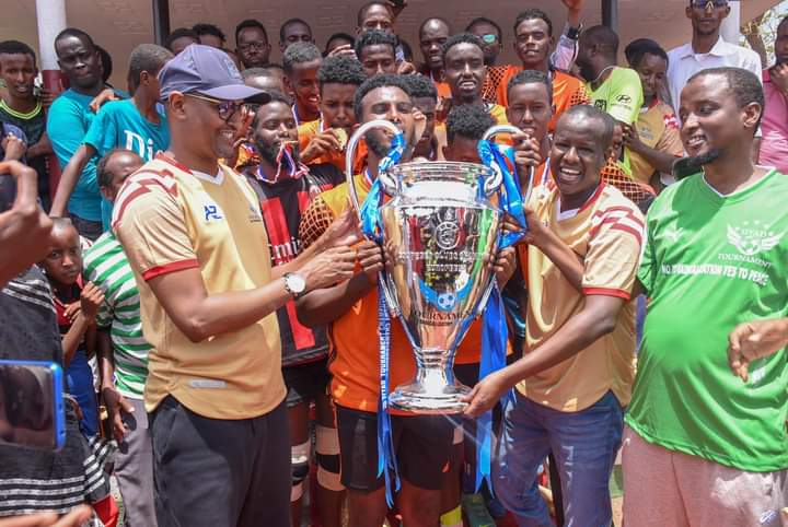 Wajir business man Siyad Hassan presents the trophy to Wajir Youth Junior-round 4 FC together Principal Secretary Youth Affairs Ismail Maalim.