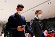 Novak Djokovic walks in Melbourne Airport before boarding a flight, after the Federal Court upheld a government decision to cancel his visa to play in the Australian Open