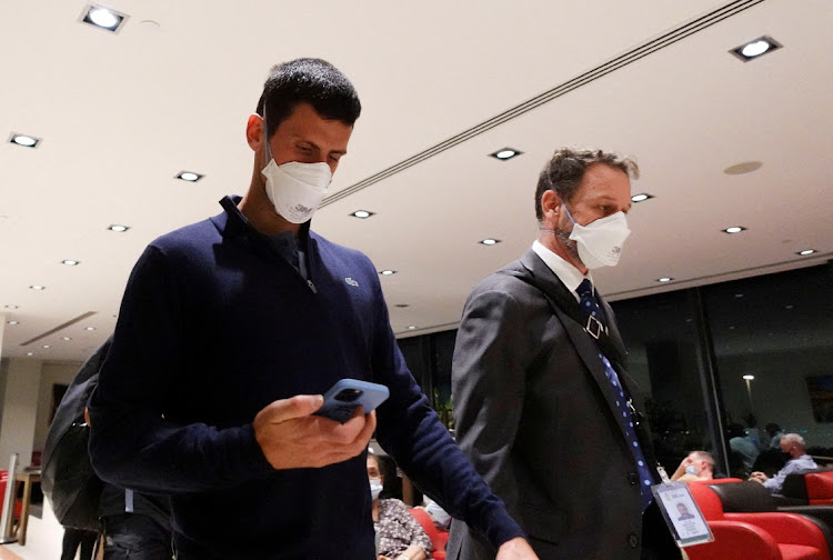 Novak Djokovic walks in Melbourne Airport before boarding a flight, after the Federal Court upheld a government decision to cancel his visa to play in the Australian Open