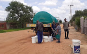 Some of Hammanskraal residents line up for their turn to fill up water buckets from the water tanker.