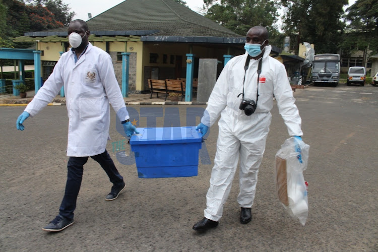 Homicide detectives carry samples after a postmortem on the bodies of Alvina Mutheu 3 and Henry Jackton,4 at Chiromo Funeral Parlour on Tuesday, July 7, 2020.