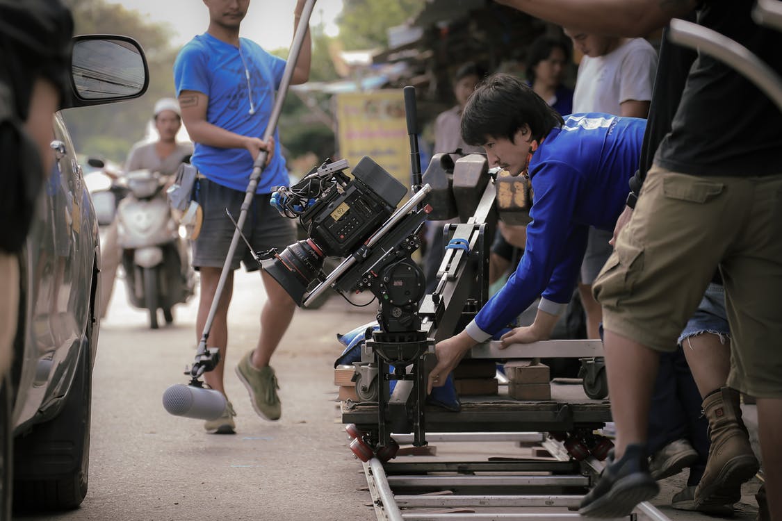 man operating camera on a busy film set