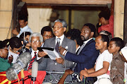 Nelson Mandela on the Cape Town City Hall balcony on February 11 1990, flanked by Walter Sisulu and Cyril Ramaphosa.