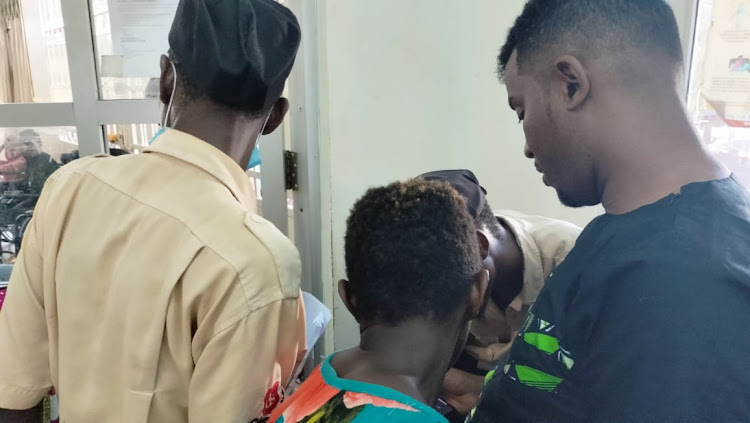 Haki Africa's Mathias Shipeta [R] with the family of Robert Gituhu at the Coast General Teaching and Referral Hospital in Mombasa on Friday.