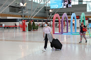 People wearing masks walk through a mostly empty domestic terminal at Sydney Airport after surrounding states shut their borders to New South Wales in response to an outbreak of the coronavirus disease (Covid-19) in Sydney, Australia, December 21, 2020.  