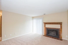 Living Room with neutral carpet and walls featuring a fireplace