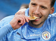 Manchester City's Ruben Dias celebrates with his medal after winning the Premier League.