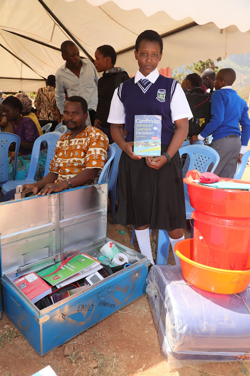 Emily Mabemba a beneficiary of the 2023 Taita Taveta County Comprehensive Secondary School Scholarship Programme packs her books in a box in Mwatate on February 6, 2023