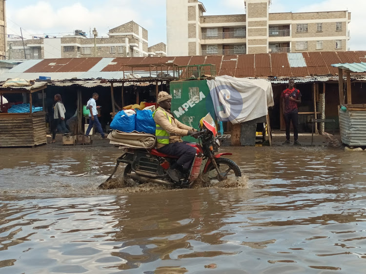 A bodaaboda rider wades through flooded waters at Maziwa area in Imara Daima following a downpour. The improper drainage system have caused a nightmare to those involved with them appealing to the local authorities to take up the matter. March 23, 2023