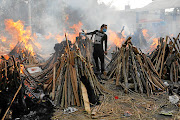 A man performs last rites next to the funeral pyres of people who died from Covid-19, during a mass cremation in New Delhi, India. The country experienced its deadliest day on Thursday this week, when 3,645 people died from the disease. 