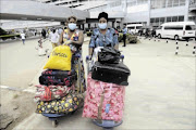 DANGEROUS TIMES: Passengers  arriving at the Lagos airport wear  face masks and  gloves photo:  AFP