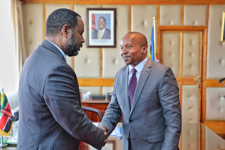 Interior CS Kindike Kithure shaking hands with an official from UN Migration Friday, December 9.