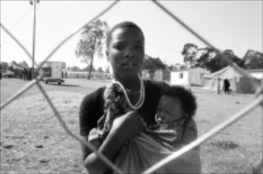 CROSSFIRE: Narcisa Macamo, 20, with her baby, Lurdes, witnessed the fracas yesterday at the camp for victims of xenophobia in Glenanda, south of Johannesburg. Pic. Antonio Muchave. 17/07/08. © Sowetan.