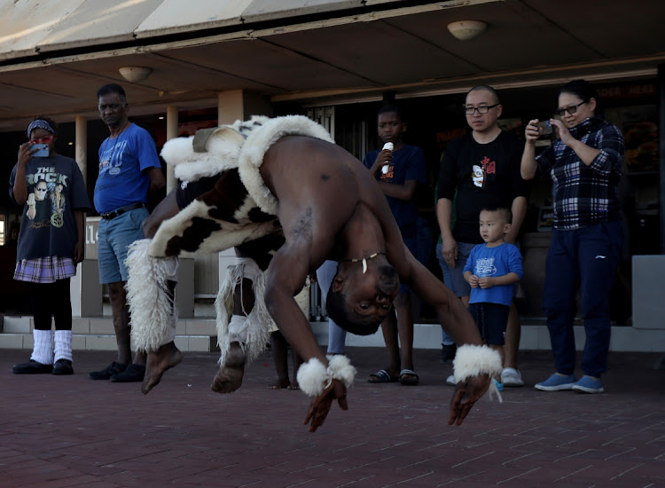 A member of African Zebra Kings from Ntuzuma entertains people at Durban beachfront. The group is also searching for children across racial lines to join them.