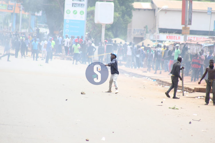 Protesters hurling stones at anti-riot police officers in Kisumu after their bid to access the CBD was thwarted on March 27, 2023.