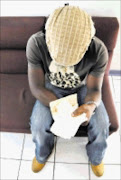 SHREDDED: Ramsy Tambong Ning with his torn passport. 16/12/08. Pic. Vathiswa Ruselo. © Sowetan.