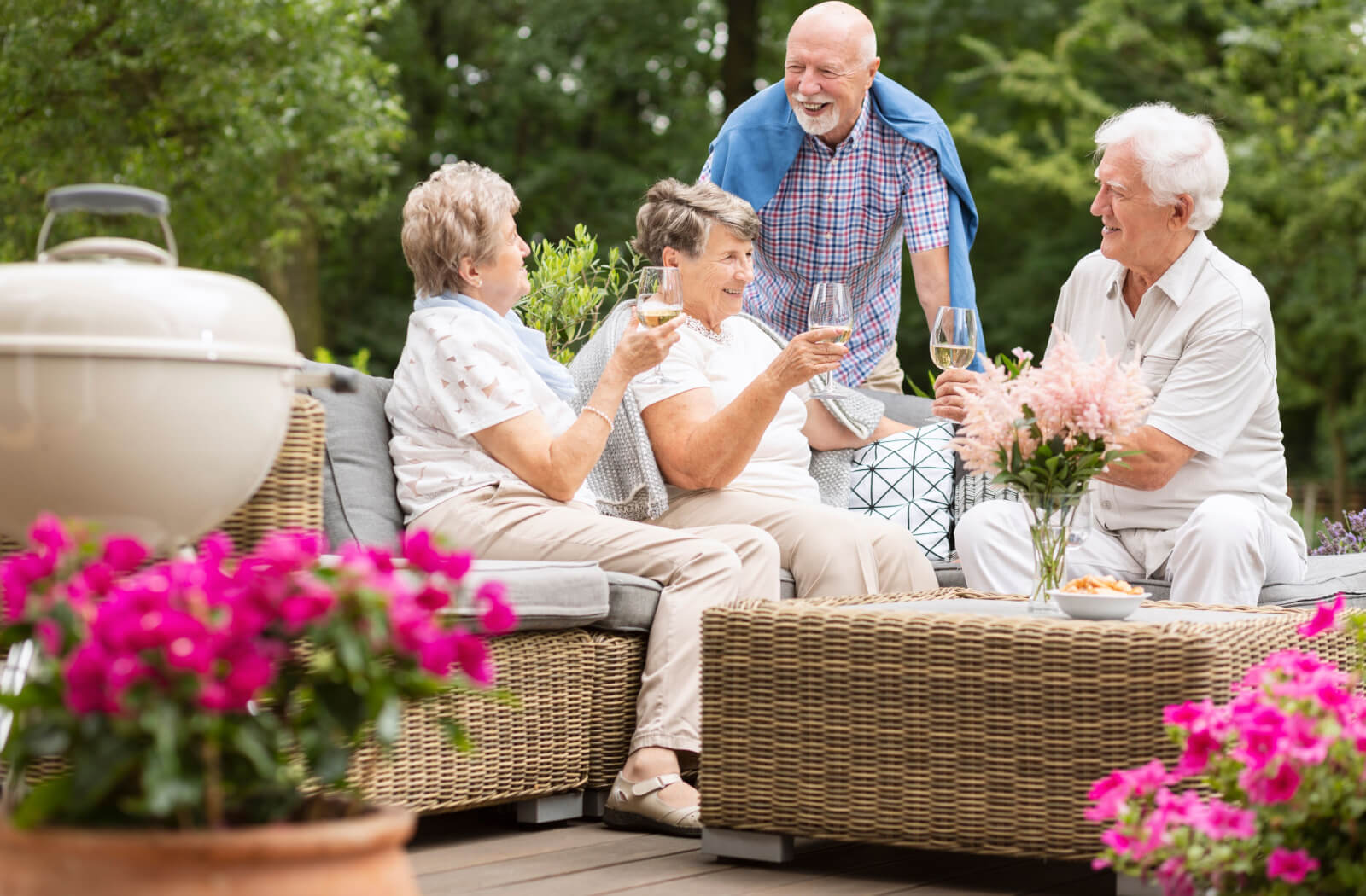 Two happy senior couples having a lovely conversation in an outdoor garden.