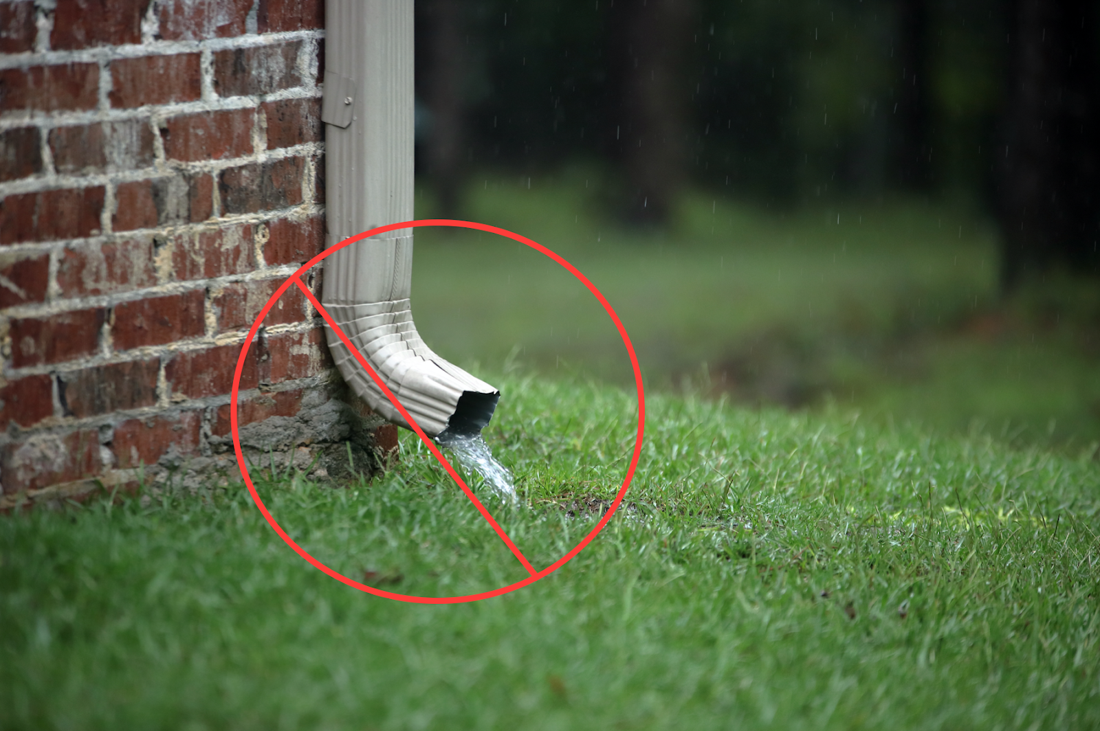 Downspout pouring water near foundation 