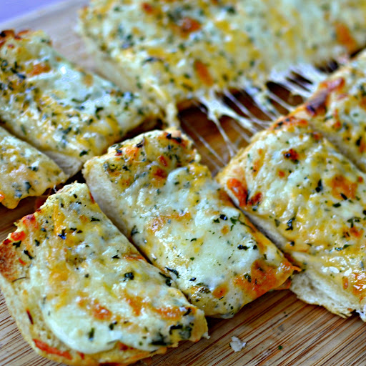 A easy to make tasty loaf of Italian or French bread topped with garlic butter, mozzarella, cheddar, provolone and baked to golden perfection.