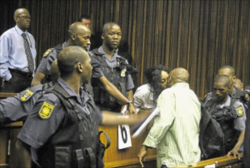 IN LOVE: Convicted terrorist Henry Okah kisses his wife Azukah in the Johannesburg High court yesterday. Okah's legal team withdrew from the case. PHOTO: Sibusiso Msibi