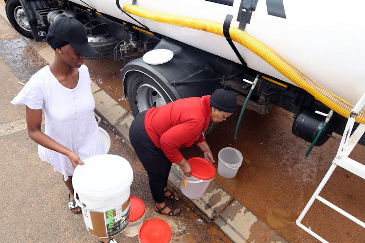 Jojina Kgantshi, left, and Masego Maluleke of Beirut, Mabopane, in Tshwane, collect water from a municipal tanker.