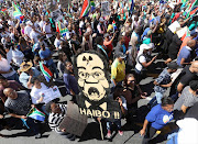 Demonstrators in Cape Town gather around a huge Zuma-nuclear mask. There are fears that President Jacob Zuma will agree to lavish spending on nuclear power stations which were opposed by his sacked finance minister.