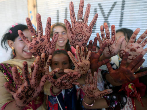 Displaced Iraqi girls who fled their homes pose as they celebrate Eid al-Fitr, in Mosul, Iraq June 25, 2017. /REUTERS